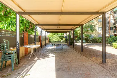an outdoor patio with tables and chairs and awning at Apartamento Cabrera Montserrat in Cabrera de Mar