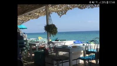 a table and chairs on a beach with the ocean at Apartamento Cabrera Montserrat in Cabrera de Mar
