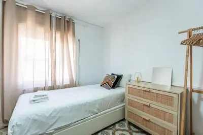 a bedroom with a bed and a dresser and a window at Feel Welcome Barcelona 10 in Cornellà de Llobregat