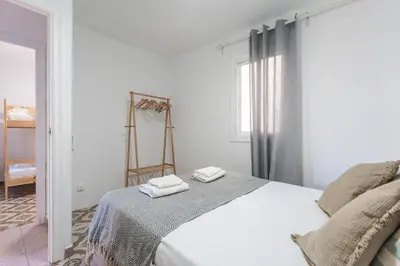 a white bedroom with a bed with two towels on it at Feel Welcome Barcelona 10 in Cornellà de Llobregat