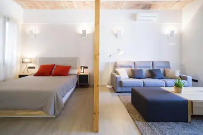 a bedroom with a bed and a blue couch at Barcelona InLoft in Barcelona