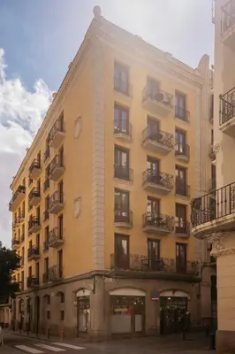 a large yellow building with balconies on a street at Barcelona Apartment Milà in Barcelona