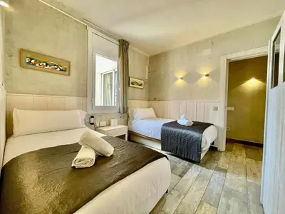 a hotel room with two beds and a window at BarcelonaForRent Market Penthouse in Barcelona