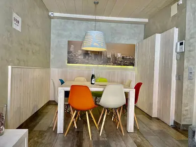 a dining room with a table with chairs and a light fixture at BarcelonaForRent Market Penthouse in Barcelona