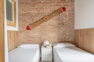 a bedroom with two beds and a baseball bat on the wall at Stay U-nique Apartment Tamarit in Barcelona