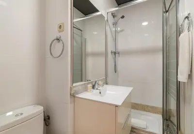 a white bathroom with a sink and a shower at Stay U-nique Apartments Torre d'En Damians II in Barcelona