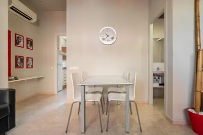 a table and chairs in a room with a clock on the wall at Stay U-nique Apartments Torre d'En Damians II in Barcelona