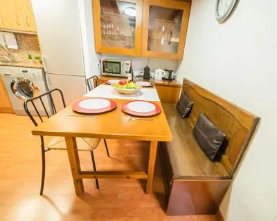 a kitchen with a wooden table with a bowl of fruit on it at Rustic Poble Sec Apartment in Barcelona