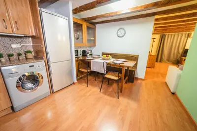 a kitchen with a table and a refrigerator at Rustic Poble Sec Apartment in Barcelona