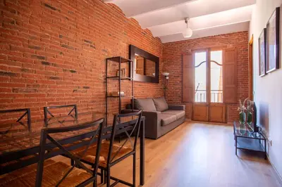 a living room with a brick wall and a couch at Eixample Sagrada Familia Apartments II in Barcelona
