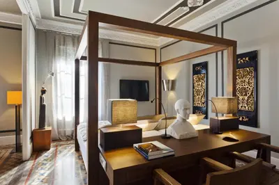 a room with a desk and a bed with a mirror at SuiteaBCN in Barcelona