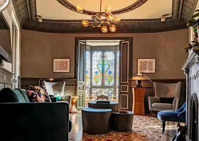 a living room with a chandelier and a stained glass window at SuiteaBCN in Barcelona