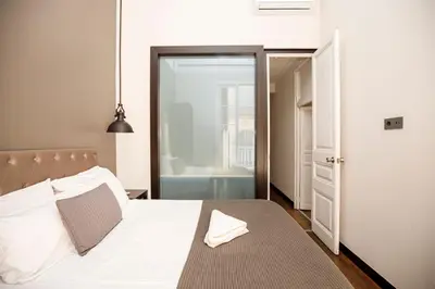 a bedroom with a white bed and a bathroom at Classic styled apartment in Barcelona