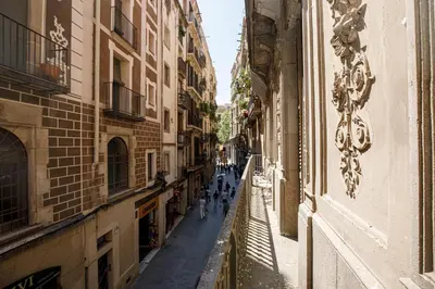 an alley with people walking down a street between buildings at Classic styled apartment in Barcelona