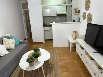 a living room with a couch and a table and a tv at Preciosas vistas al mar en Castelldefels in Castelldefels