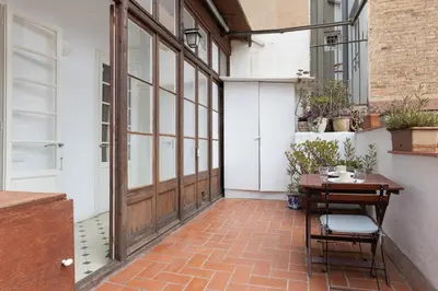 a patio with a wooden door and a table at Housalia Paseo de Gracia in Barcelona