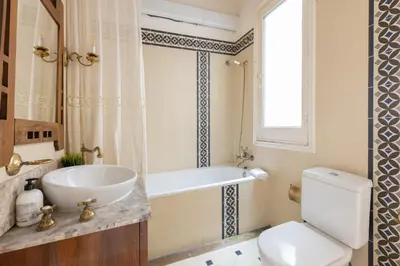 a bathroom with a sink and a tub and a toilet at Housalia Paseo de Gracia in Barcelona