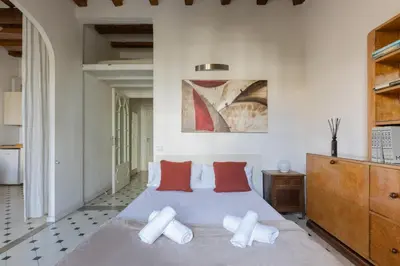 a bedroom with a large bed with red and white pillows at Housalia Paseo de Gracia in Barcelona