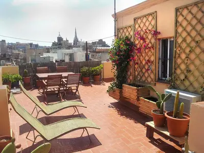 a patio with chairs and tables and potted plants at The Panoramic View Born Penthouse in Barcelona