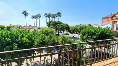 a balcony with a view of a beach and palm trees at Apartamento Cabrera Burriac in Cabrera de Mar