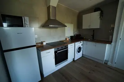 a kitchen with a white refrigerator and a dishwasher at Apartament Roca Foradada in Monistrol