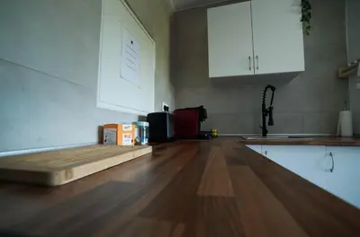 a kitchen with a wooden floor and white cabinets at Apartament Roca Foradada in Monistrol