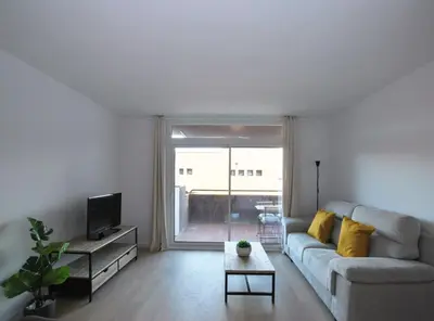 a living room with a couch and a tv at Santa Maria apartment in Vilassar de Mar
