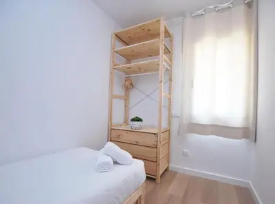 a small bedroom with two beds and a shelf at Santa Maria apartment in Vilassar de Mar