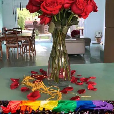 a vase filled with red roses sitting on a table at Lemon Tree GuestHouse in Tiana