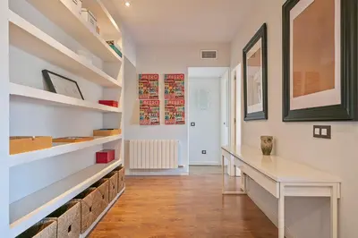 a hallway with a white table and shelves at Luxury Muntaner Plaza in Barcelona