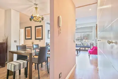 a dining room and living room with a table and chairs at Luxury Muntaner Plaza in Barcelona