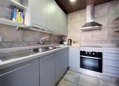 a kitchen with white cabinets and a sink at Stay U-nique Apartment Parallel in Barcelona