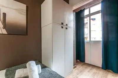 a bedroom with a white cabinet and a bed at Stay U-nique Apartment Parallel in Barcelona
