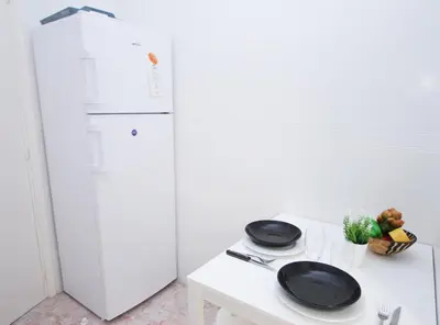 a kitchen with a white refrigerator and two plates on a table at Can Josep in Vilassar de Mar