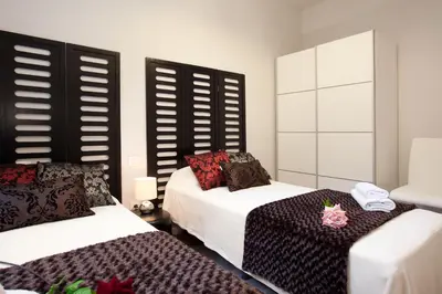 a bedroom with two beds and a table in it at APBCN Eixample Center in Barcelona