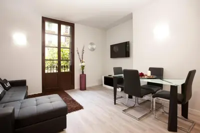 a living room with a table and chairs and a couch at APBCN Eixample Center in Barcelona