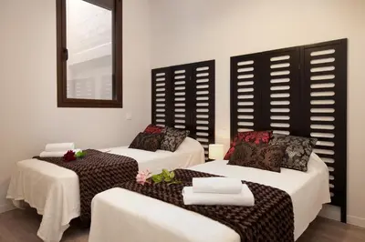 a room with two beds and a mirror at APBCN Eixample Center in Barcelona