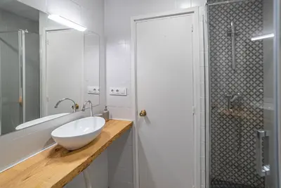 a white bathroom with a sink and a shower at Welcomy Sant Andreu in Barcelona