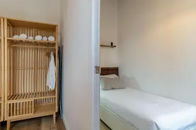 a small bedroom with a bed and a closet at Canela Homes BARCELONA CÒRSEGA in Barcelona