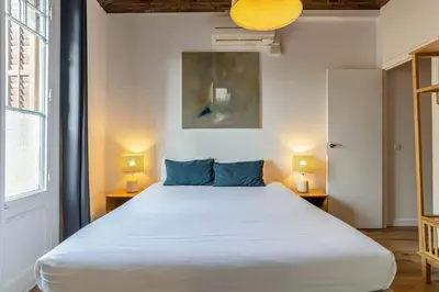 a large white bed in a room with two lamps at Canela Homes BARCELONA CÒRSEGA in Barcelona