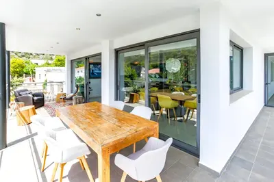 a dining room with a wooden table and white chairs at Tranquil large 6 bedroom family Villa sleeps 20 near sitges in Sant Pere de Ribes
