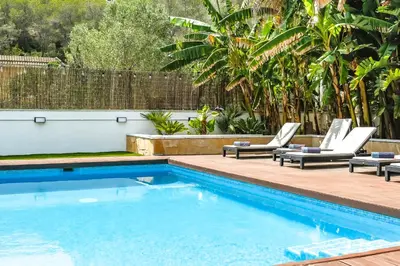 a swimming pool with two lounge chairs next to a swimming pool at Tranquil large 6 bedroom family Villa sleeps 20 near sitges in Sant Pere de Ribes
