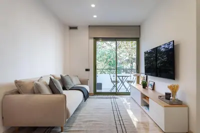 a living room with a couch and a tv at Cozy Apartment Les Corts in Barcelona