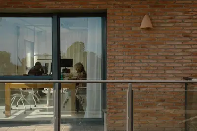 a woman sitting at a table in front of a window at Circles House Coliving & Coworking in Barcelona