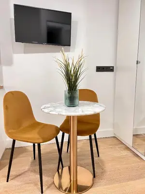 a table with two chairs and a potted plant on it at Crysoyle Apartment Barcelona Next to Camp Nou in Hospitalet de Llobregat