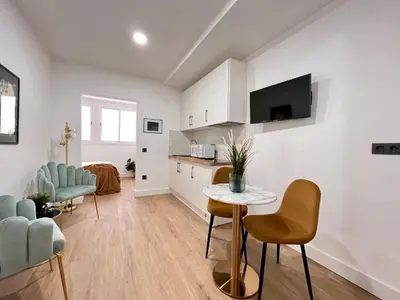 a kitchen and living room with a table and chairs at Crysoyle Apartment Barcelona Next to Camp Nou in Hospitalet de Llobregat