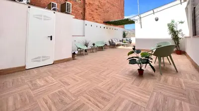 a room with a wooden floor and chairs and tables at Crysoyle Apartment Barcelona Next to Camp Nou in Hospitalet de Llobregat