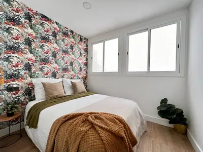 a bedroom with a large bed with a floral wallpaper at Crysoyle Apartment Barcelona Next to Camp Nou in Hospitalet de Llobregat