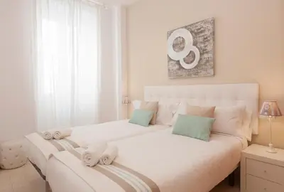 a white bedroom with two beds with towels at Blaumar in Sitges