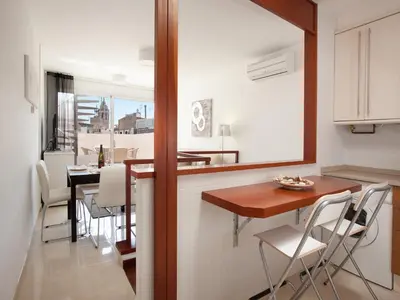 a kitchen and dining room with a table and chairs at Blaumar in Sitges